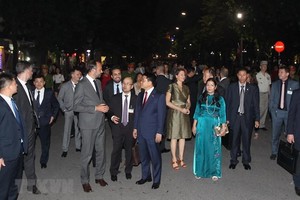 French Prime Minister Edouard Philippe and Chairman of Hanoi People's Committee talk during their walk around Hoan Kiem Lake (Photo: VNA)