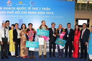 Standing Vice Chairman of the municipal People's Committee Le Thanh Liem welcomes the 7 millionth international visitor.
