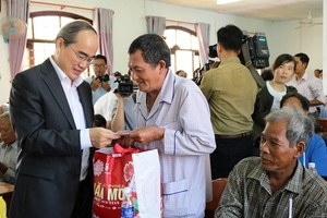 Secretary of HCMC Party Committee Nguyen Thien Nhan presents Tet gifts to local people in Chau Thanh district, Tra Vinh province. (Photo: Sggp)