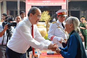 Secretary of the HCMC Party Committee Nguyen Thien Nhan talks with a delegate in the meeting. (Photo: sggp)