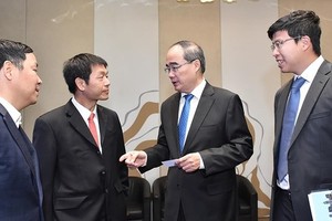 Secretary of the Ho Chi Minh City Party Committee, Nguyen Thien Nhan (2nd, R) talks with delegates at the seminar. (Photo: SGGP))