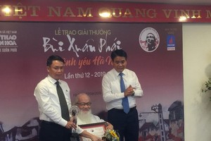 Assoc. Prof. Dr. Nguyen Thua receives the Grand Prize at the 12th Bui Xuan Phai Award-Love for Hanoi. (Photo: Sggp)