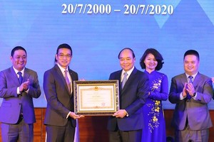 Prime Minister Nguyen Xuan Phuc (third, right) presents a merit certificate to the Ho Chi Minh Stock Exchange at the ceremony on July 20 (Photo: VNA)