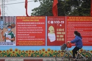 A billboard sharing COVID-19 prevention measures on a street in Hanoi (Photo: VNA)