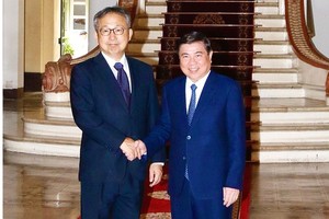  Chairman of the municipal People’s Committee, Nguyen Thanh Phong (R) and  Ambassador Extraordinary and Plenipotentiary of Japan Yamada Takio. (Photo: SGGP)