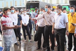 HCMC People's Committee Vice Chairman Duong Anh Duc leads a delegation to inspect the epidemic prevention and control at Binh Dien whosale market. (Photo: SGGP)