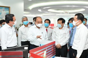 President Nguyen Xuan Phuc (C) and Secretary of the Party Committee of HCMC Nguyen Van Nen (L) visit the SGGP Newspaper. (Photo: SGGP)