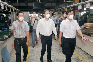Vice Chairman of the HCMC People’s Committee Duong Anh Duc (C) inspect the working area related to Covid-19 case in PouYuen Vietnam Company. (Photo: SGGP)