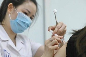 A medical worker gives a shot of Nano Covax to a volunteer in the third-phase trials at the Hanoi-based Vietnam Military Medical University (Photo: VNA)