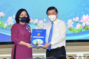 Chairman of the People’s Committee of HCMC, Nguyen Thanh Phong (R) hands over the appointment decision to Ms. Nguyen Thi Thu Huong. (Photo: SGGP)