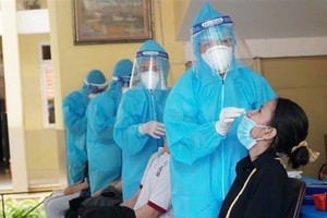 Medical workers take samples of pupils at Nguyen Binh Khiem Primary School in Ho Chi Minh City for Covid-19 testing (Photo: VNA) 