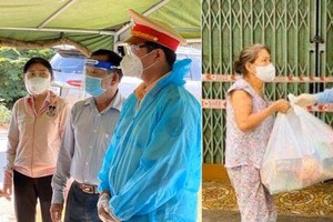 Vice secretaries of the municipal Party Committee, Nguyen Thi Le (L) and Nguyen Ho Hai  visit people and the security forces in the blocked sites and bule zones  in Cu Chi and Tan Binh districts amid restrictions on social distance. (Photo: SGGP) ​