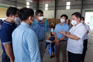 HCMC People's Committee Vice Chairman Duong Anh Duc (R) inspects the Covid-19 vaccination at the Nam Anh Production and Trade Company in the Tan Tao Industrial Zone in Binh Tan District. (Photo: SGGP)