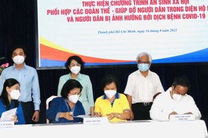 Chairwoman of Vietnam Fatherland Front Committee in Ho Chi Minh City To Thi Bich Chau (C, standing) cum director of the HCMC Social Security Center attends the signing ceremony. (Photo: SGGP)
