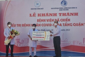 Vice secretary of the HCMC Party Committee Nguyen Ho Hai (R) presents the field hospital two High Flow Nasal Cannula (HFNS) machines. (Photo: SGGP)