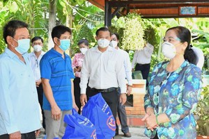 Chairwoman of the People’s Council of HCMC Nguyen Thi Le (R) presents gifts to needy people in Binh Chanh District. (Photo: SGGP)