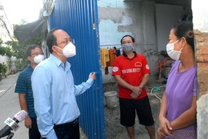 Vice Secretary of the HCMC Party Committee Nguyen Ho Hai talks with workers who have to stay at a construction site during social distancing measures. (Photo: SGGP)