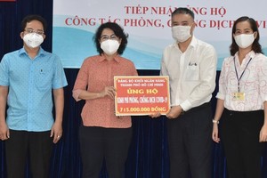 Chairwoman of the Vietnam Fatherland Front of HCMC, To Thi Bich Chau receives a cash assistance of the Party Committee of the banking sector in HCMC . (Photo: SGGP)