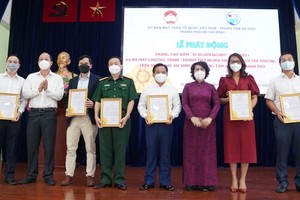 Vice Secretary of the HCMC Party Committee Nguyen Ho Hai (2nd,L) and Chairwoman of the HCMC chapter of Vietnam Fatherland Front To Thi Bich Chau (3rd, R) present letters of thank to donators. (Photo: SGGP)
