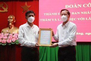 Chairman of the People’s Committee of HCMC Phan Van Mai (R) hands over a letter of thanks to Soc Trang for the province's support to the city's Covid-19 fight. (Photo: SGGP)