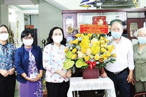 Chairwoman of the HCMC People’s Council Nguyen Thi Le (3rd, L) visits People’s Teacher, Assoc. Prof. PhD Huynh Van Hoang (2nd, R). (Photo: SGGP)