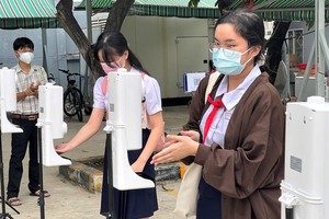 Students of the Saigon Practice High School in District 5 wash their hands before entering the class.