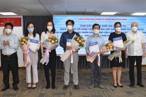 Head of the Propaganda and Education Board of the City Party Committee Phan Nguyen Nhu Khue (R) presents awards to winners the 15th National Press Awards in 2020.