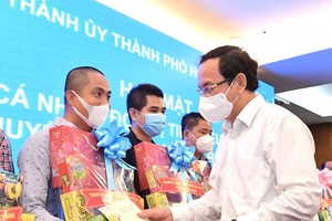 Secretary of the Party Committee of HCMC Nguyen Van Nen presents gifts to drivers.