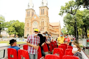  Foreign visitors take hop-on hop-off bus tour in HCMC.