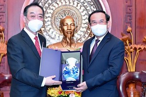 Secretary of the municipal Party Committee Nguyen Van Nen (R) presents a gift to  Chinese Consul General in HCMC Wu Jun. (Photo: SGGP)