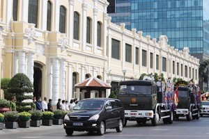 The funeral procession runs across the HCMC People's Committee Head Office. (Photo: SGGP)