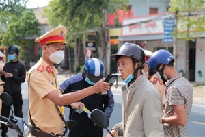 A traffic officer of Phu Thien district, the Central Highlands province of Gia Lai, administering a breathalyser test on a road user during rush hour. (Photo: VNA)