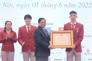 Prime Minister Pham Minh Chinh (front, left) presents a second-class Labor Order to swimmer Nguyen Huy Hoang. (Photo: VNA)