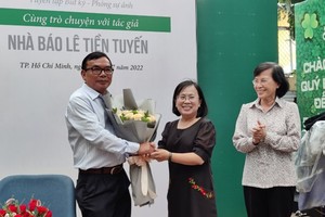 Ms. Dinh Thi Thanh Thuy, Director of the HCMC General Publishing House (C) and former Vice Secretary of the Party Committee and former Chairwoman of the People's Council of HCMC Pham Phuong Thao (R) congratulate Journalist Le Tien Tuyen.