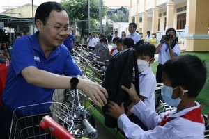 Vice Secretary of the HCMC Party Committee Nguyen Van Hieu offers gifts to students.