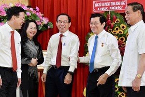 Politburo member, Permanent member of the Party Central Committee's Secretariat Vo Van Thuong (L), former Permanent member of the Party Central Committee Secretariat, Le Hong Anh (R), Secretary of the HCMC Party Committee Nguyen Van Nen (C) congratulate f
