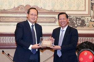 Phan Van Mai, Chairman of the HCMC People's Committee (right) hands over a souvenir to Tan See Leng, Singapore’s Minister for Manpower and Second Minister for Trade and Industry. (Photo: VNA)
