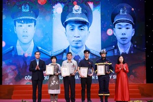 President of the Vietnam General Confederation of Labor Nguyen Dinh Khang (L) hands over Certificates of merit to the Fire and Rescue Police Section of the Cau Giay Police District Station in Hanoi.