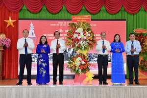 HCMC's leaders (L) presents flowers to Cu Chi District's leaders (R) celebrating 55 years of receiving the title “Iron Land and Bronze Citadel” .