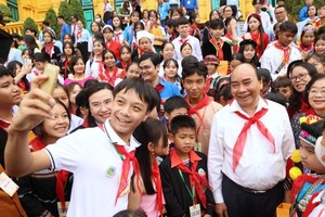 President Nguyen Xuan Phuc poses for a photo with children (Photo: SGGP)