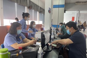 Passengers buy train tickets at a station.