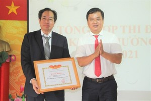 Deputy Chief of the Office of the Ministry of Labor - Invalids and Social Affairs in HCMC, Nguyen Hong Tay (R)  offers a certificate of merit to the 1A Hospital.