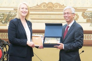 Vice Chairman of the People’s Committee of HCMC Vo Van Hoan presents a souvenir gift to Deputy Chief Minister of Australia’s Northern Territory Nicole Manison.