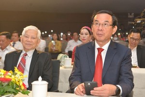 Secretary of the HCMC Party Commitee Nguyen Van Nen (R) sends a text message to donate to the fund.