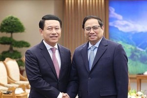 Prime Minister Pham Minh Chinh (R) receives Lao Deputy PM and Minister of Foreign Affairs Saleumxay Kommasith in Hanoi on December 7. (Photo: VNA)