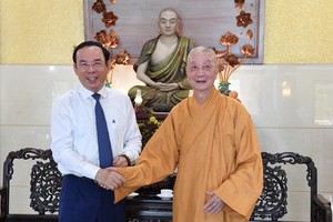 Secretary of the municipal Party Committee Nguyen Van Nen (L) offers Tet greetings to Most Venerable Thich Tri Quang. (Photo: SGGP)