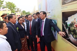 Chairman of the HCMC People’s Committee Phan Van Mai (R) and Governor of Savannakhet Province, Bounchom Ubonpaseuth (L) attend an exhibition on the upgrading project of a memorial complex dedicated to President Ho Chi Minh in Laos. (Photo: SGGP)