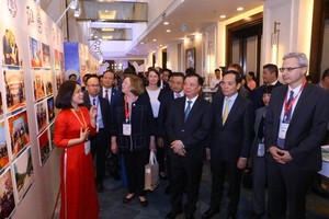 Officials visit the photo exhibition at Melia Hotel in Hanoi on April 14. (Photo: SGGP)
