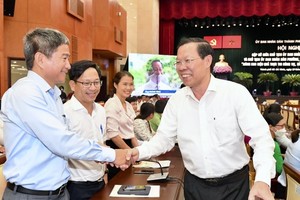 Chairman of the HCMC People’s Committee Phan Van Mai meets delegates at the meeting. (Photo: SGGP)