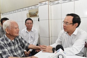 Secretary of the Municipal Party Committee Nguyen Van Nen (R) visits Mr. Ngo Quang Chinh. (Photo: SGGP)